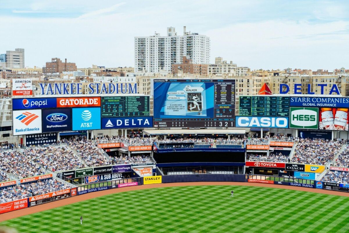 Yankee Stadium filled with spectators, with billboards, advertisements, and a large scoreboard—each detail reflecting the expertise of a design consultancy visible above the outfield.